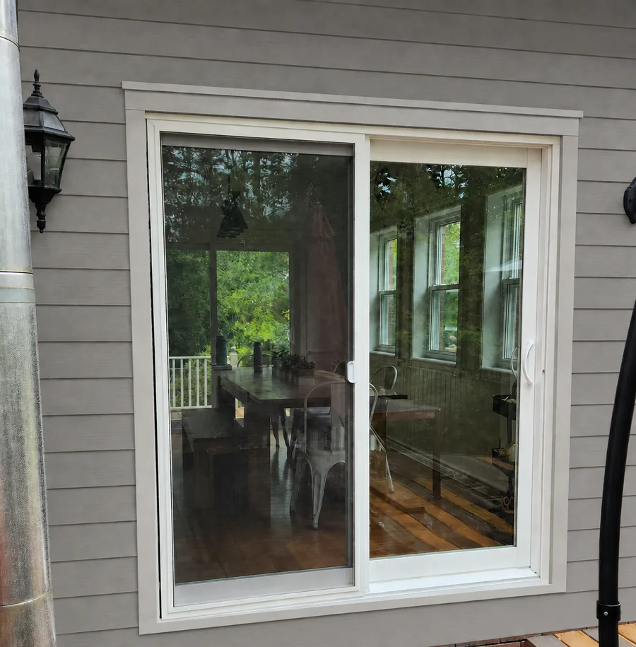 White sliding patio door installed with premium siding on a Langdon home